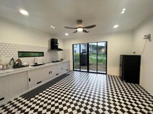 a kitchen with a black refrigerator and a checkered floor at My Homestay in Tuaran
