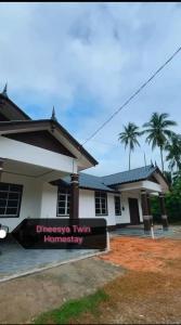 a house with a sign in front of it at Dneesya homestay in Kuala Terengganu