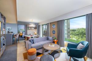 een woonkamer met een bank en een tafel bij ibis Styles Mysuru in Mysore