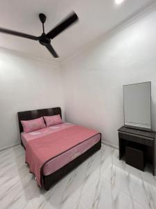 a bedroom with a bed and a ceiling fan at Dneesya homestay in Kuala Terengganu