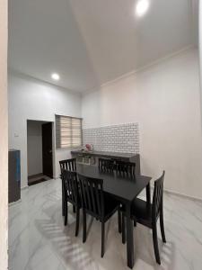 a dining room with a black table and chairs at Dneesya homestay in Kuala Terengganu