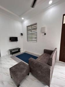 a living room with a couch and a flat screen tv at Dneesya homestay in Kuala Terengganu