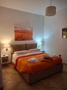 a bedroom with a bed with an orange blanket at ARISTOCASA in Lecce