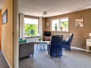 een woonkamer met een bank, stoelen en een tafel bij Stunning apartment in Schoorl, North Hollandâ you can bike to the beach in Schoorl