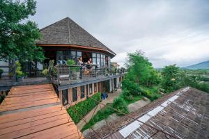 ein Gebäude mit Menschen, die auf einem Balkon stehen in der Unterkunft Rai Ruen Rom Organic and Farmstay in Ban Sawan + 16 Fotos