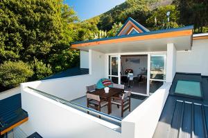 una casa con patio, tavolo e piscina di Beach loft Makorori a Wainui