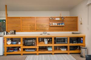 uno scaffale di legno con sopra forni a microonde ed elettrodomestici di Beach loft Makorori a Wainui Altre 6 foto