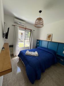 une chambre avec un lit bleu avec deux serviettes dessus dans l'établissement Dunas Delfin, à Monte Hermoso 56 autres photos