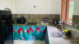a kitchen with a counter with a blue table with flowers on it at Happy Haven in Hikkaduwa