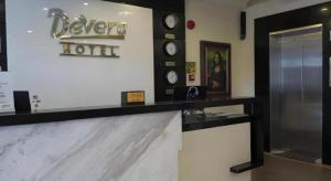 un comptoir de réception d'hôtel avec des horloges murales dans l'établissement Devera Hotel, à Ángeles