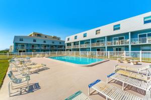 een zwembad met banken en een gebouw bij Seabreakers 1 in South Patrick