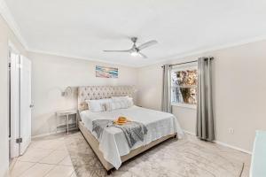 een witte slaapkamer met een bed en een raam bij Seabreakers 1 in South Patrick +40 foto's