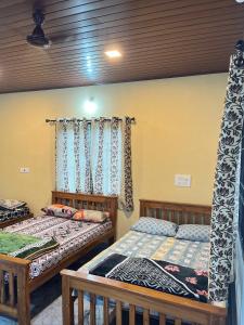 a bedroom with two beds and a window at Malnad cloud homestay Agumbe in Someshwar