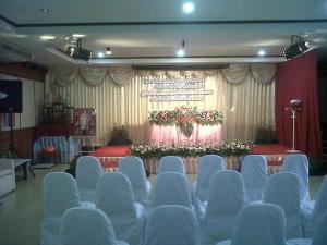 een auditorium met blauwe stoelen voor een podium bij Kasem Garden Hotel Surin in Ban Nong Tao