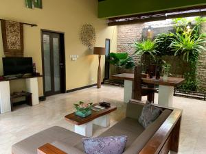 een woonkamer met een bank en een tafel bij Nike Villas in Sanur