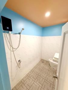 a bathroom with a shower with a toilet and a tv at Garden Hostel Koh Rong in Koh Rong Island