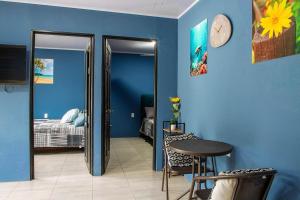 ein blaues Zimmer mit einem Bett und einer Uhr an der Wand in der Unterkunft Apartment Steps fr View Los Sueños Adventure Park in Herradura