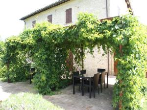 een tafel en stoelen onder een met klimop begroeide boog bij Modern holiday home in Foligno - Loc with pool in Case Vecchie
