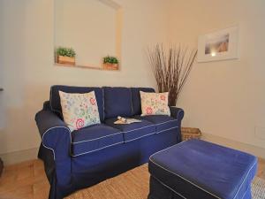 een blauwe bank met kussens en een kruk in een woonkamer bij Modern holiday home in Foligno - Loc with pool in Case Vecchie