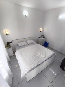 a white bedroom with a bed with white sheets at Orchid Lake View Resort in Paravūr