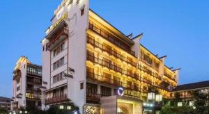 een hoog wit gebouw met een klok erop bij Wuxi Zenmore Hotel in Wuxi