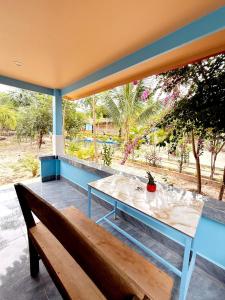 a wooden bench sitting on a porch with a table at Garden Hostel Koh Rong in Koh Rong Island
