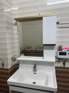 a white sink in a kitchen with a mirror at 44 đặng dung in Buon Ma Thuot