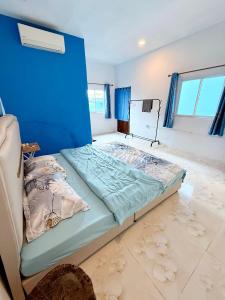 a bedroom with a bed with a blue wall at Garden Hostel Koh Rong in Koh Rong Island +23 photos