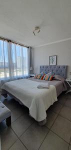 een slaapkamer met een groot bed in een kamer met ramen bij I A pasos de la playa y del centro in La Serena