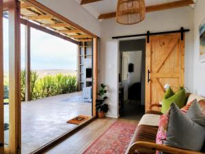 a living room with a couch and a sliding glass door at Countryside Container Home in Baardskeerdersbos