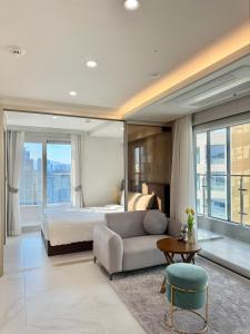 una camera da letto con un letto, un divano e un tavolo di Raviens Maison de Hotel a Busan Altre 81 foto