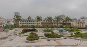 een park met bomen en struiken in een stad bij Bati Holiday Hotel in Zhongshan