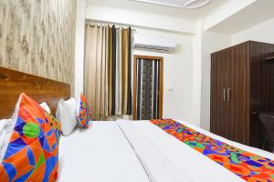 una camera da letto con un grande letto con una coperta colorata di FabHotel Divine a Gurgaon