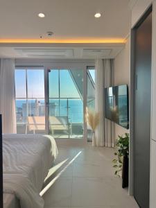 una camera da letto con un letto e vista sull'oceano di Raviens Maison de Hotel a Busan