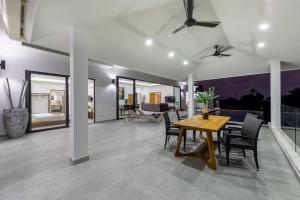 ein Wohnzimmer mit einem Holztisch und Stühlen in der Unterkunft Elsa Villa in Strand Chaweng Noi