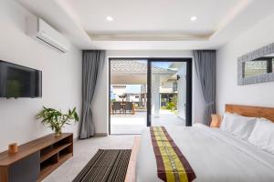 Schlafzimmer mit einem Bett, einem TV und einem Balkon in der Unterkunft Elsa Villa in Strand Chaweng Noi + 17 Fotos