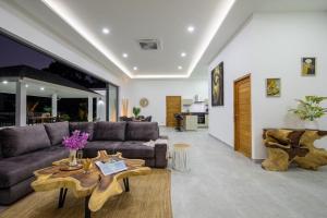 ein Wohnzimmer mit Sofa und Tisch in der Unterkunft Elsa Villa in Strand Chaweng Noi