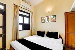 een slaapkamer met een bed en een raam bij Townhouse Calangute Formerly Hotel Horizon in Goa +53 foto's