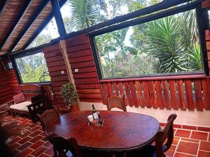 een houten tafel en stoelen in een kamer met een groot raam bij Descanso Rural Colombia in Marsella