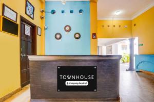 een televisie in een kamer met gele muren bij Townhouse Calangute Formerly Hotel Horizon in Goa