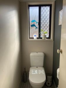 a bathroom with a toilet and a window at Exclusive Living for Professionals in Seacliff +19 photos