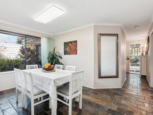 a dining room with a table and chairs and a mirror at Exclusive Living for Professionals in Seacliff