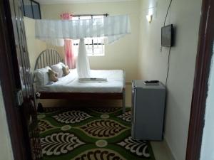 a small bedroom with a bed and a window at satelite view hotel in Webuye