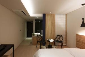 a bedroom with a bed and two chairs and a desk at Seocho H hotel in Seoul