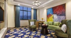 een woonkamer met een bank, stoelen en een tv bij Ramada by Wyndham Taixing in Taixing
