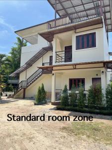 een huis met een balkon ervoor bij Bangtao Hello House in Bang Tao Beach