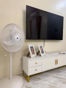 a white fan in a living room with a tv at BLJ Homes in Angatan