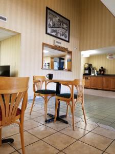 Super 8 by Wyndham Bentonville في بنتونفيل: غرفة طعام مع طاولة وكراسي