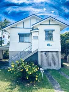 a white house with a staircase in front of it at Noosa River Gem in Noosaville
