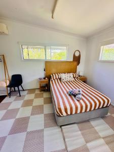 a bedroom with a bed and a checkered floor at Noosa River Gem in Noosaville